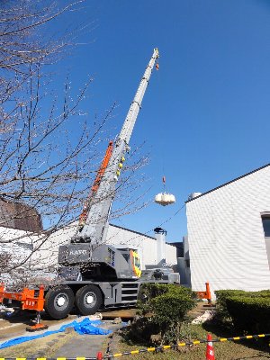 クレーン車がクレーンを上側に長く伸ばしているのを後ろ側から撮った写真