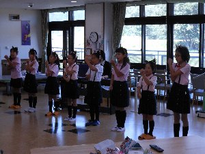 あんず少年少女合唱団の子たちが腕を動作させながら歌っている写真