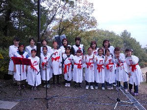 白い装束と赤い帯のあんず少年少女合唱団の集合写真