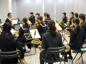 講師からサックスの基礎講座を受けている吹奏楽部の中学生の写真