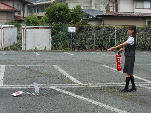 女性職員が消火器の練習で的に命中させた際の写真