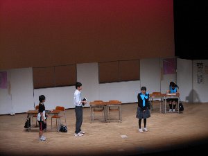 教室を模したセットと制服を着た長野俊英高校演劇部の部員たちの写真