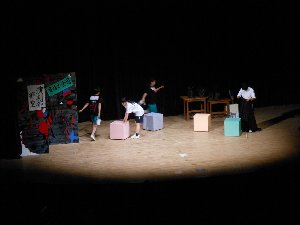舞台の上で文化学園長野高校演劇部の部員4名が芝居をしている写真